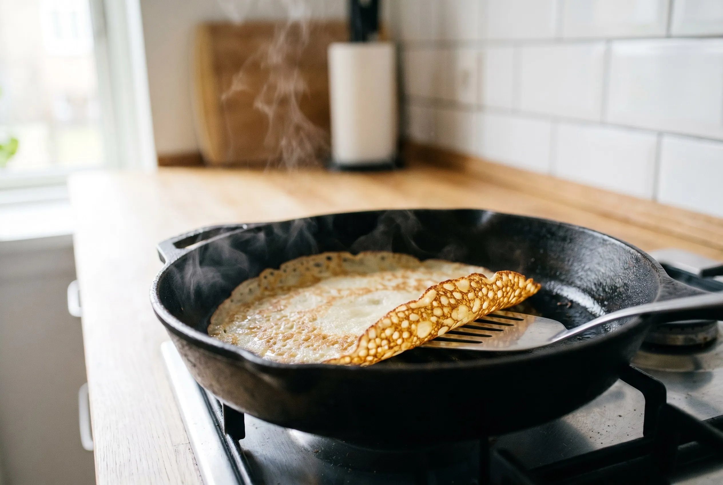 Tynd pandekage der steger i en pande